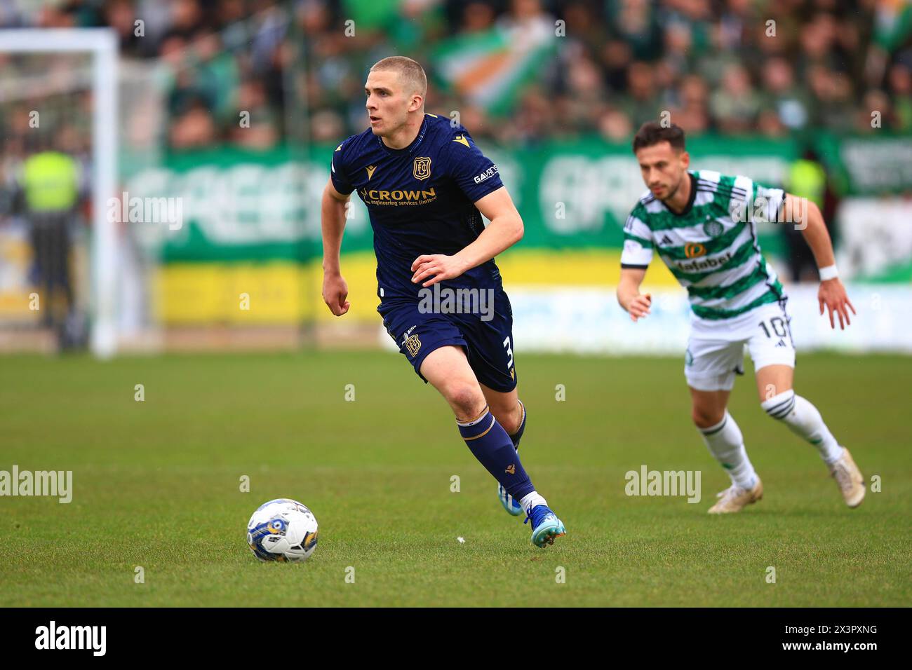 Dens Park, Dundee, UK. 28th Apr, 2024. Scottish Premiership Football, Dundee versus Celtic; Owen Dodgson of Dundee races away from Nicolas Kuhn of Celtic Credit: Action Plus Sports/Alamy Live News Stock Photo