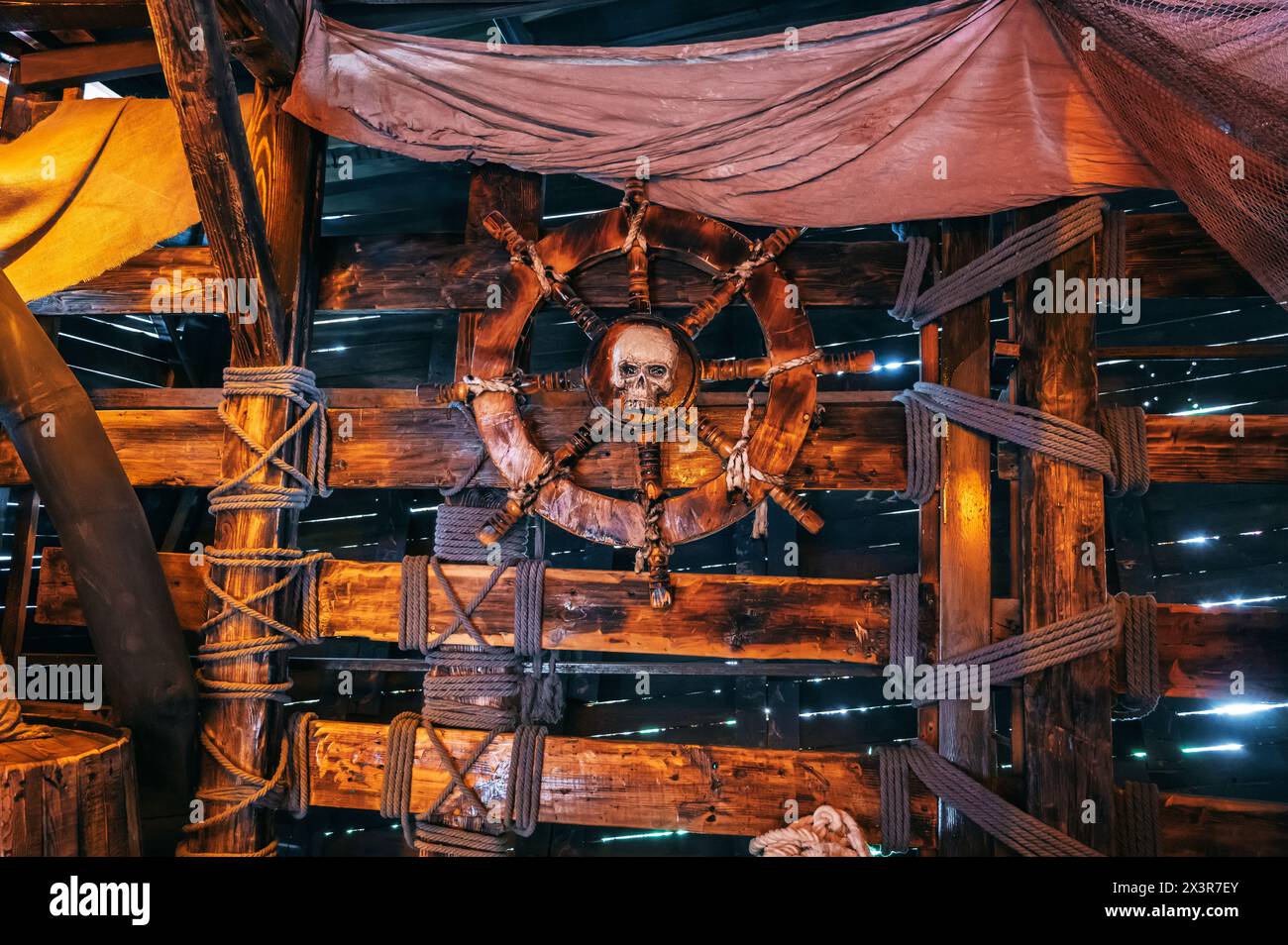 captain cabin on ancient pirate ship with a wooden steering wheel with a pirate's skull Stock Photo