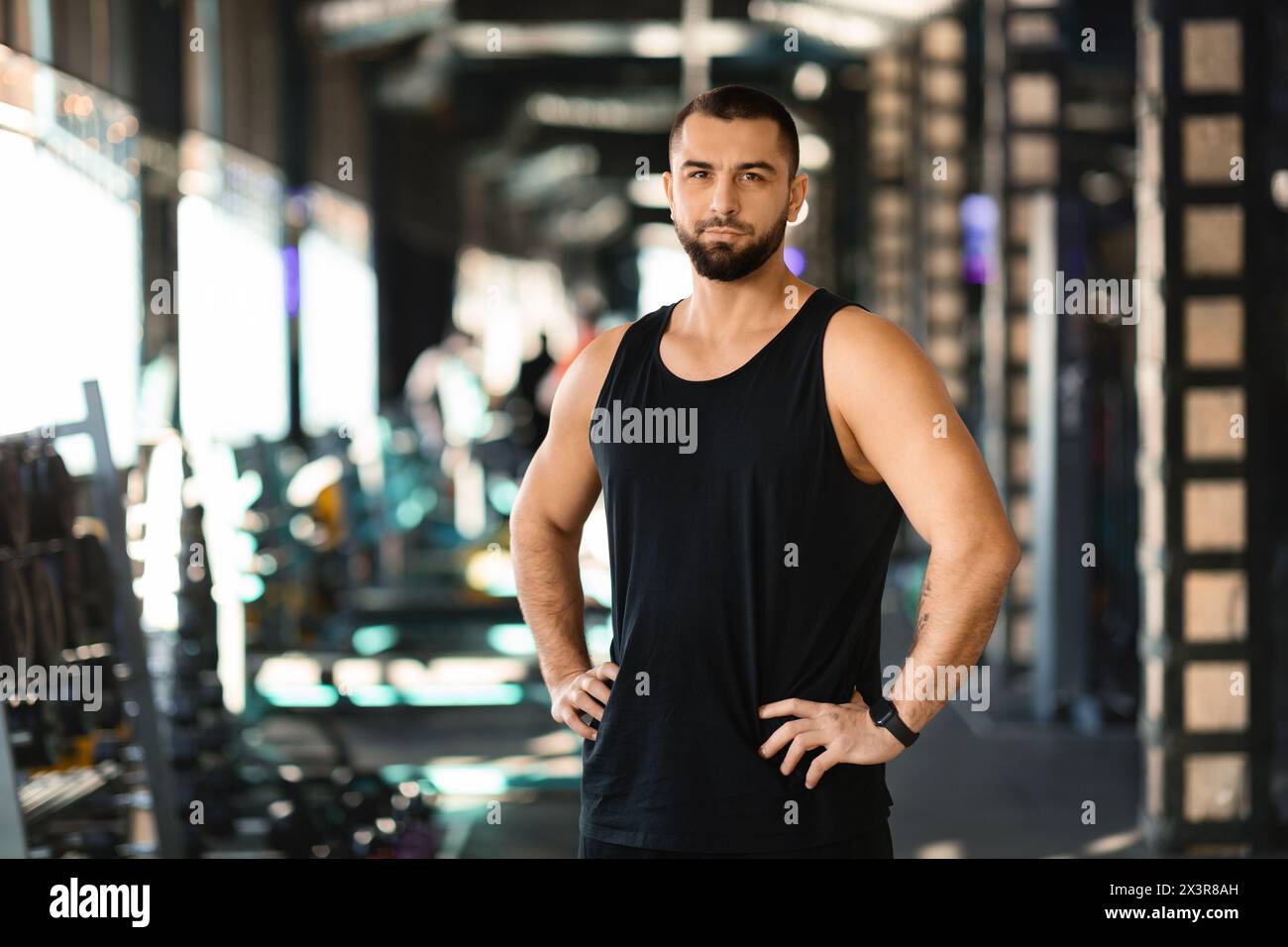 Man Standing in Gym With Hands on Hips Stock Photo