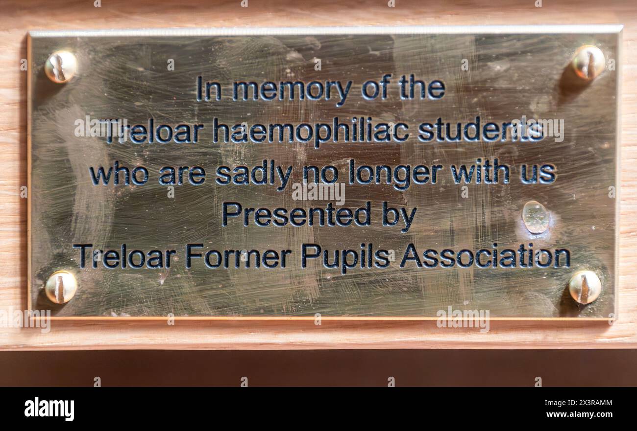 Holy Rood Church, Holybourne near Alton, Hampshire, England, UK, April 2024. Commemorative plaque on a church pew honoring the Treloar haemophiliac students who are sadly no longer with us. Historically, the Lord Mayor Treloar School was associated with the infected blood scandal, and former pupils with haemophilia have filed legal action against the school for giving them contaminated blood products infected with HIV and hepatitis in the 1970s and 1980s. Stock Photo