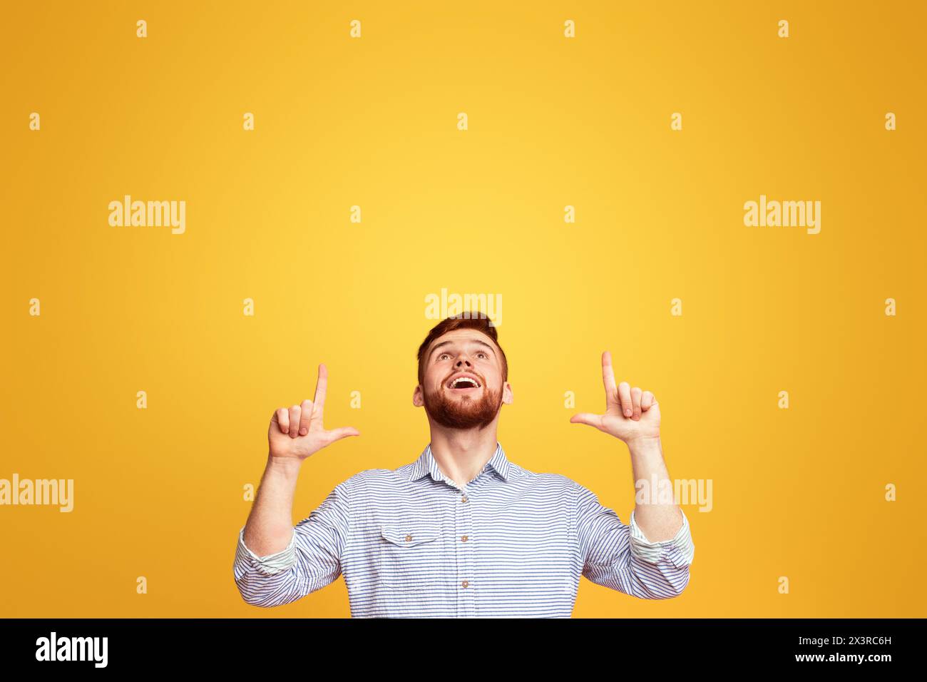 Man Raises Hands in Front of Yellow Background Stock Photo