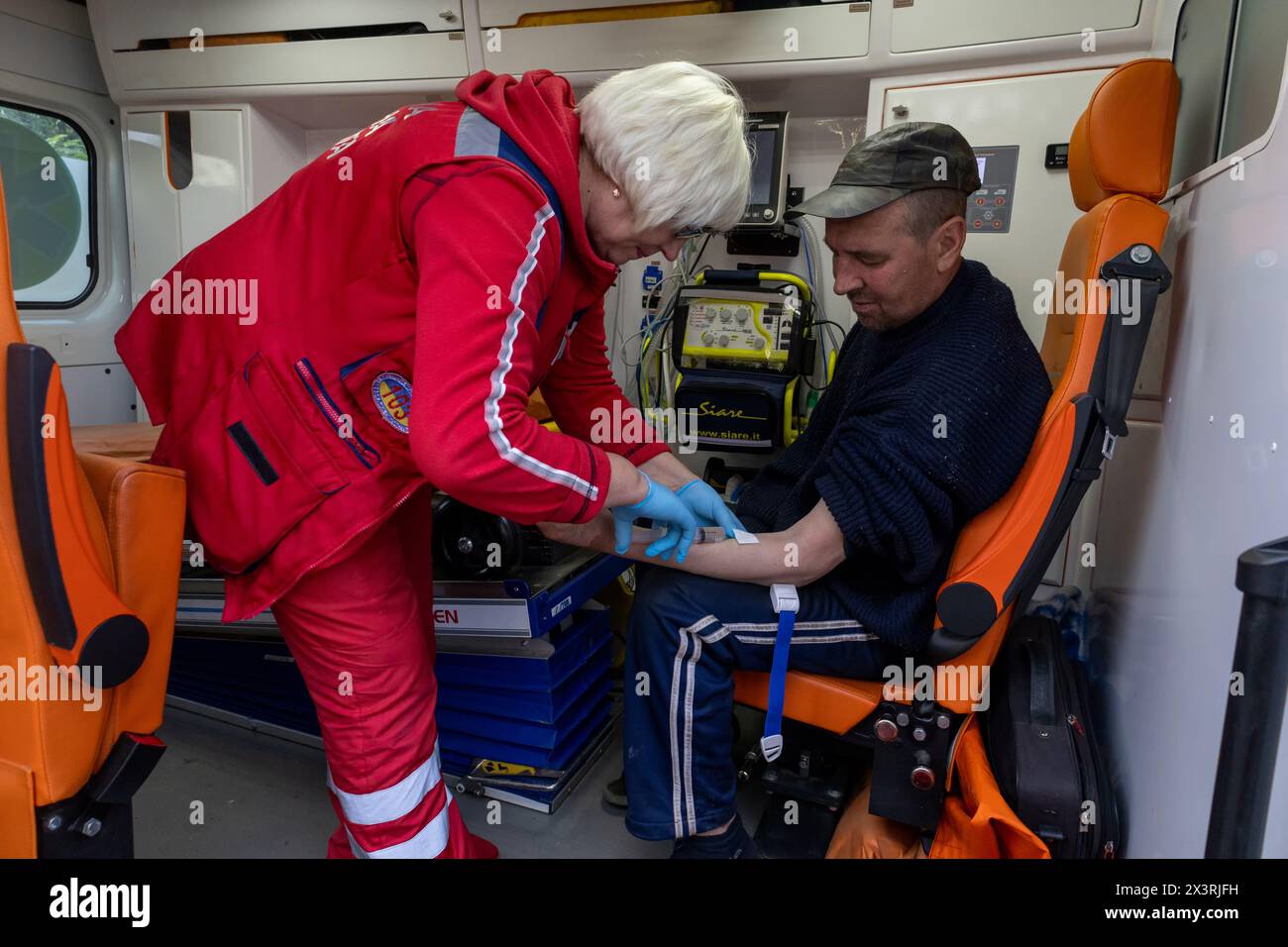 the paramedic gives an intravenous injection to the patient Stock Photo ...