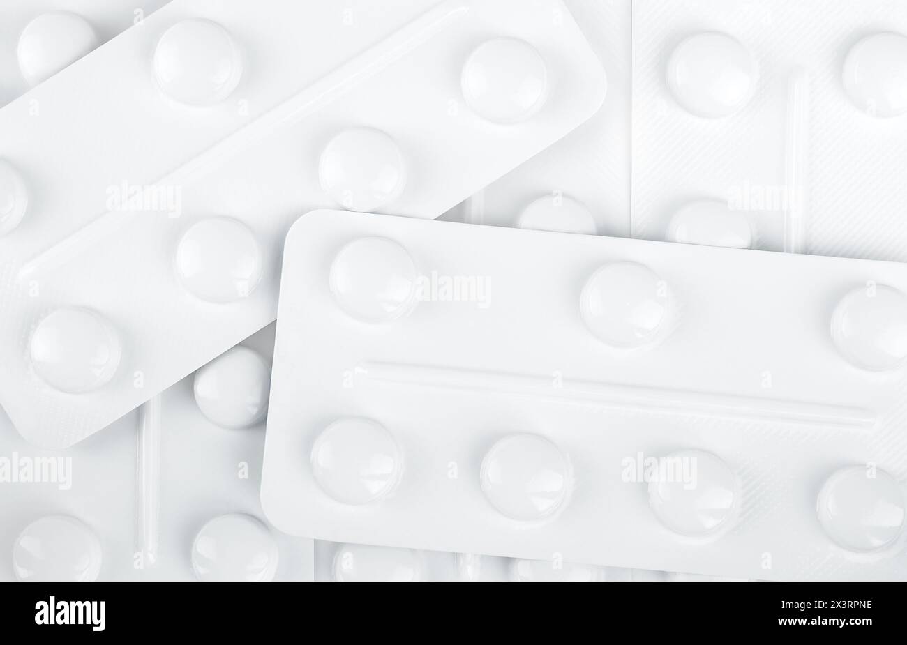 A bunch of white blisters with tablets. Medical backdrop. Top view. Stock photo. Stock Photo