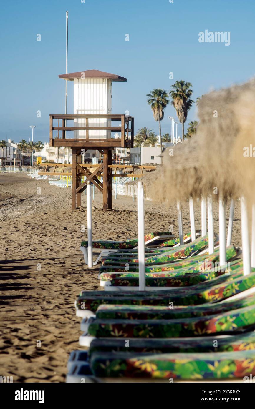 Sun loungers and umbrellas on the beach to relax while sunbathing in the Mediterranean Sea. Stock Photo