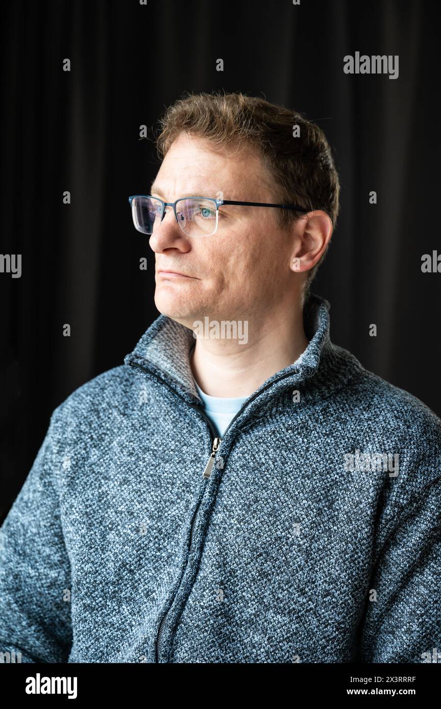 Indoor portrait of a 45 yo white man looking serious, Brussels, Belgium. Model released Stock Photo