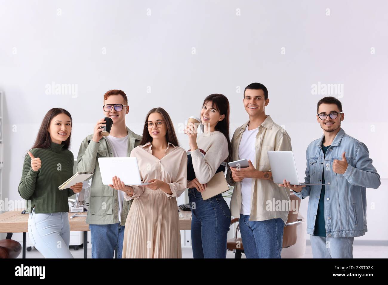 Team of young programmers with gadgets in office Stock Photo