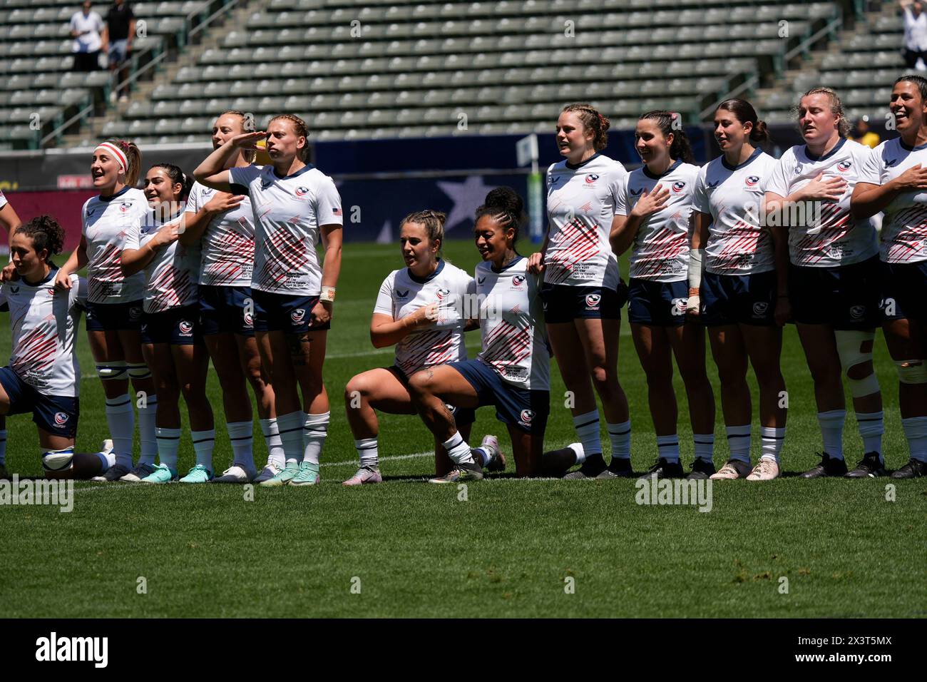 United States team members stand and kneel as the national anthem plays