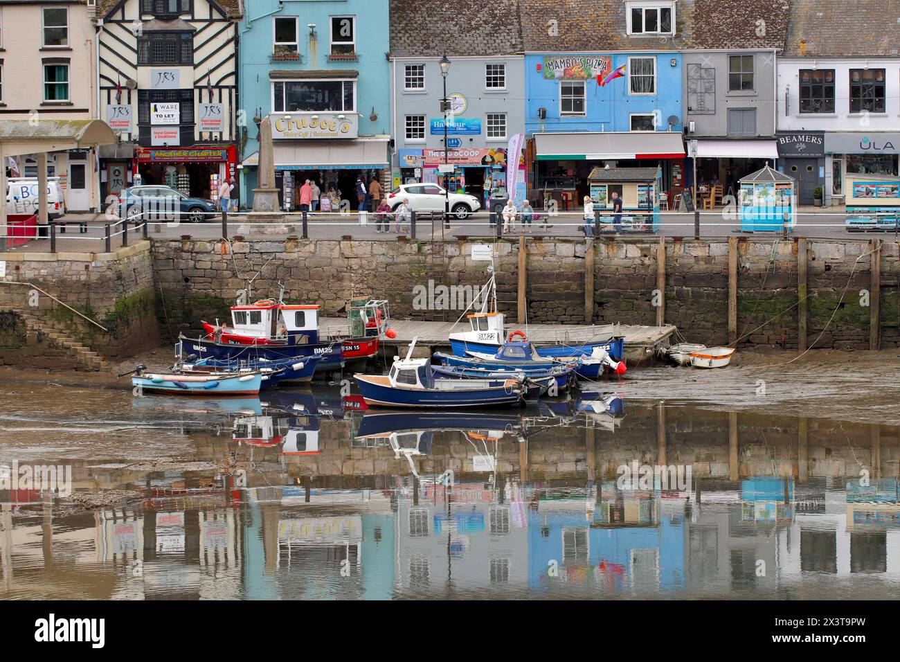 The characteristic pastel painted houses are reflected in the harbour ...