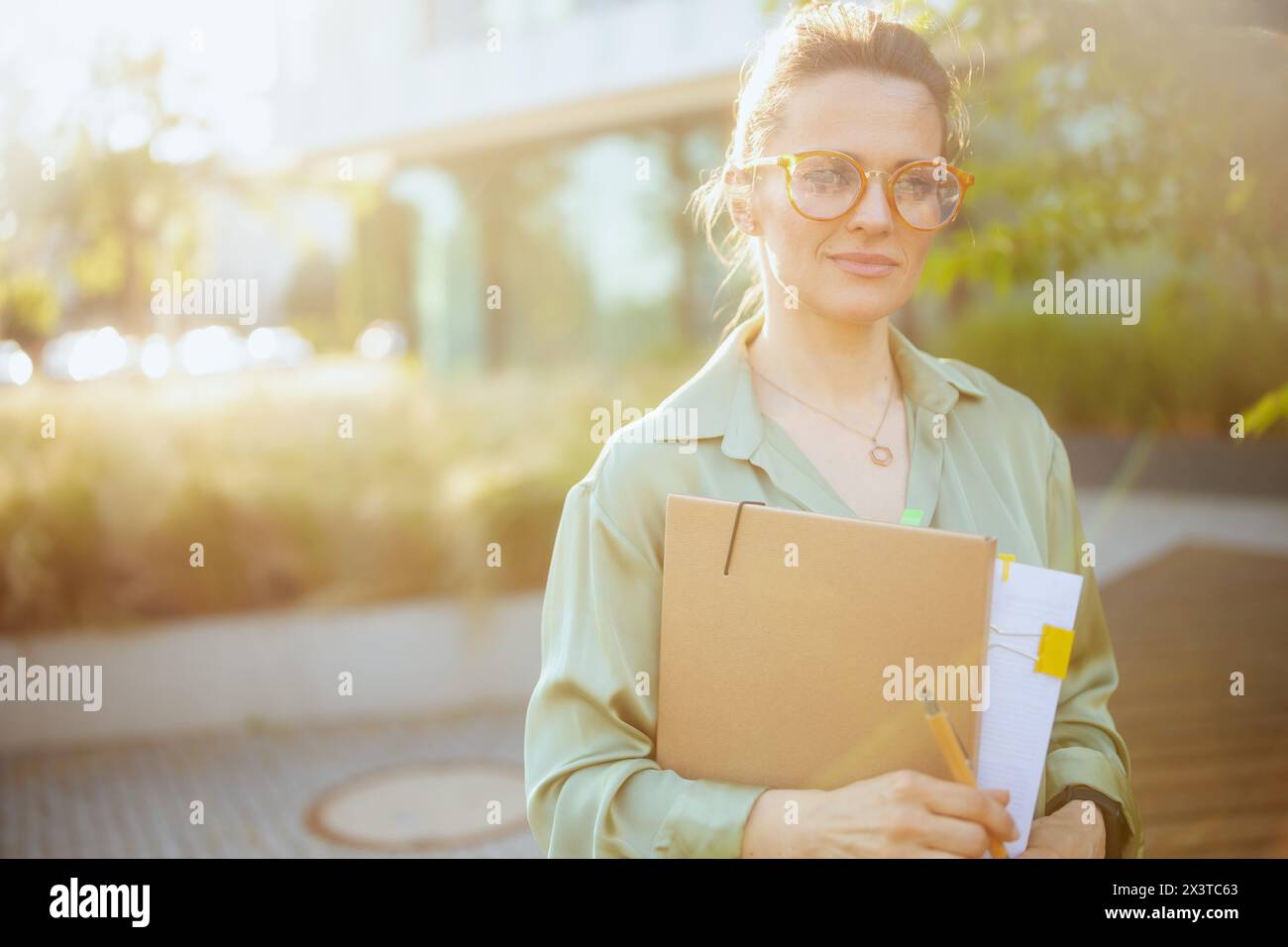 modern female employee near office building in green blouse and ...