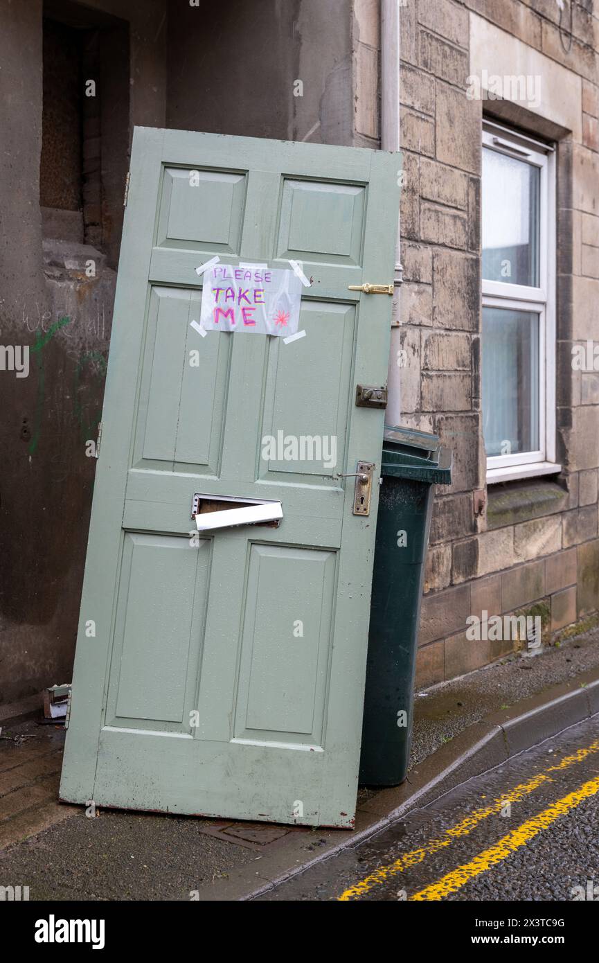 28 April 2024. Elgin,Moray,Scotland. This is a wooden door with broken letterbox all lonesome with a sign Please Take Me on it. Stock Photo