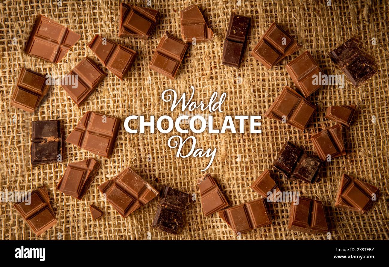 Chocolate piece background on a rustic jute background with text commemorating International Chocolate Day Stock Photo