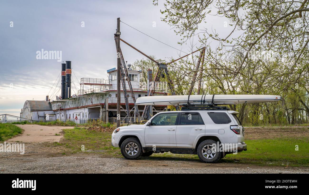 Brownville, NE, USA - April 21, 2024: Toyota 4Runner SUV with expedition canoe on a shore of Missouri River in spring scenery with a historic river dr Stock Photo