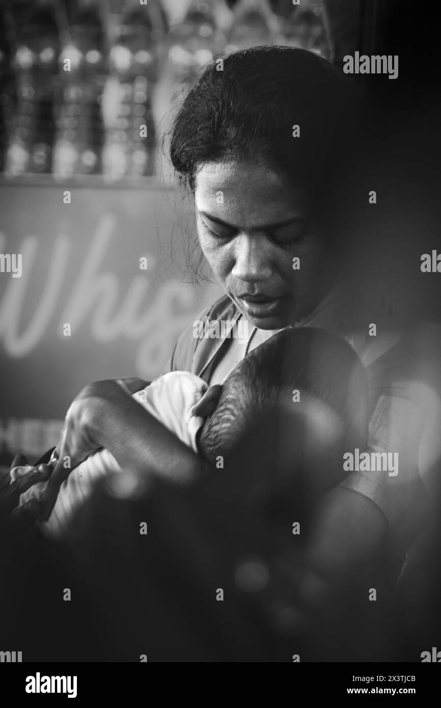 Boy in mother's arms in India is being cared. Mother and child. Mothers care and love for her child. black and white photo. Stock Photo