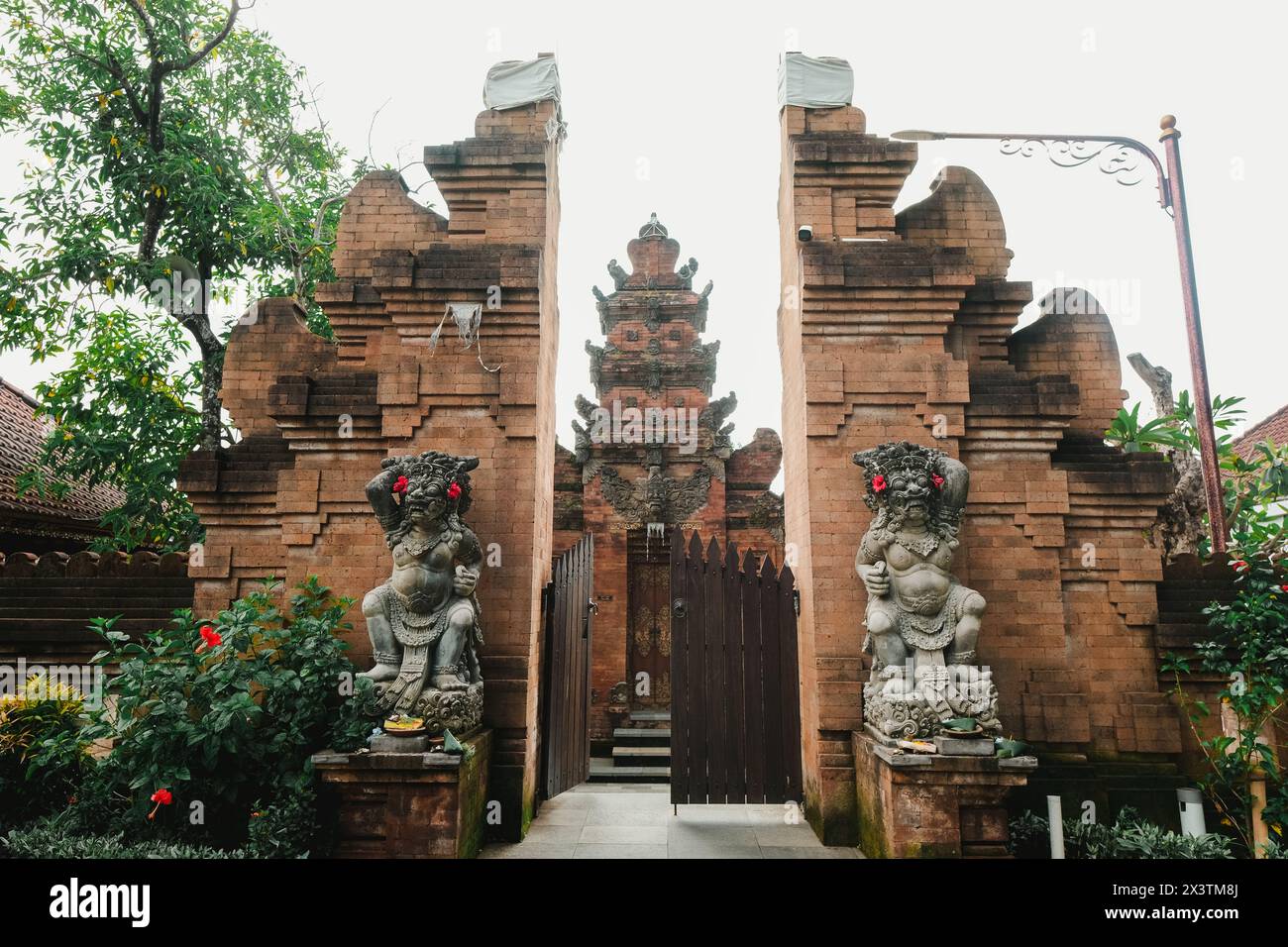 Balinese temple known as 'Pura' entrance gate usually known as 'Candi Bentar' with two guardian statues flanking the sides called Dwarapala Stock Photo