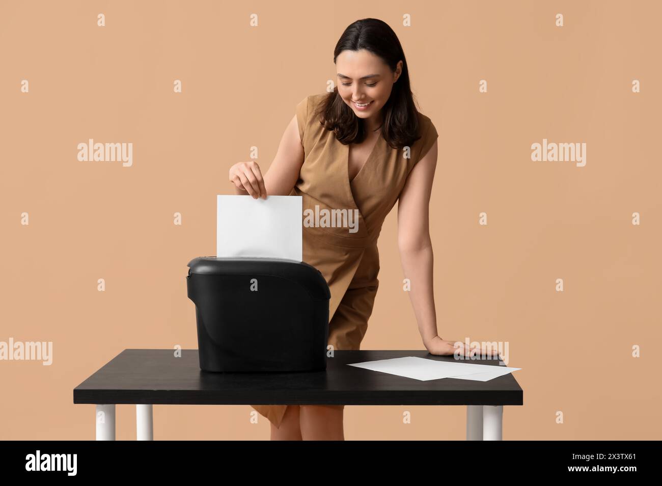 Secretary destroying document in shredder on beige background Stock ...