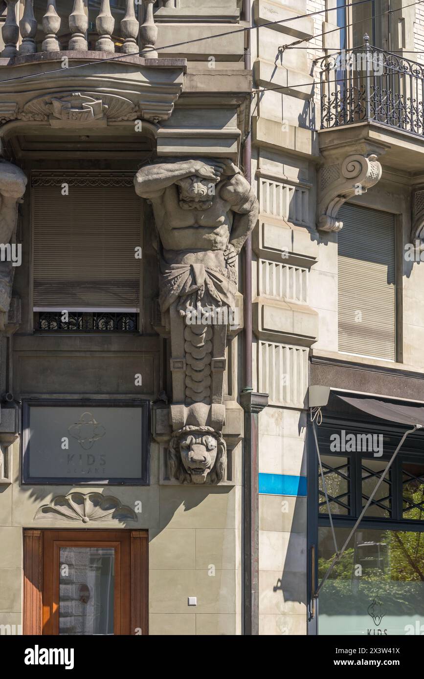 A statue in the facade of a historical building with a classic man and a lion head. Lucerne, Switzerland. Stock Photo