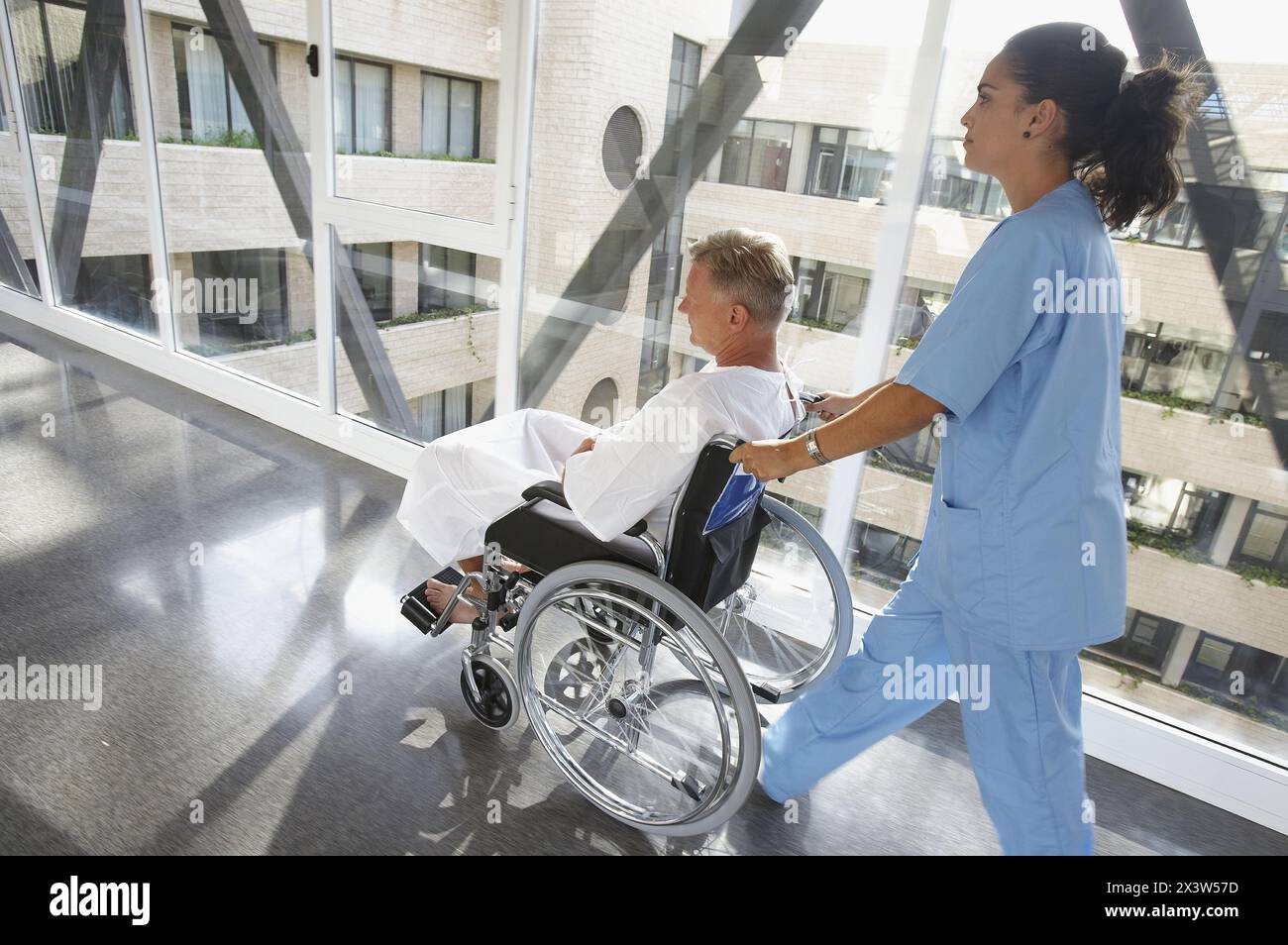Nurse pushing patient in wheelchair Stock Photo - Alamy