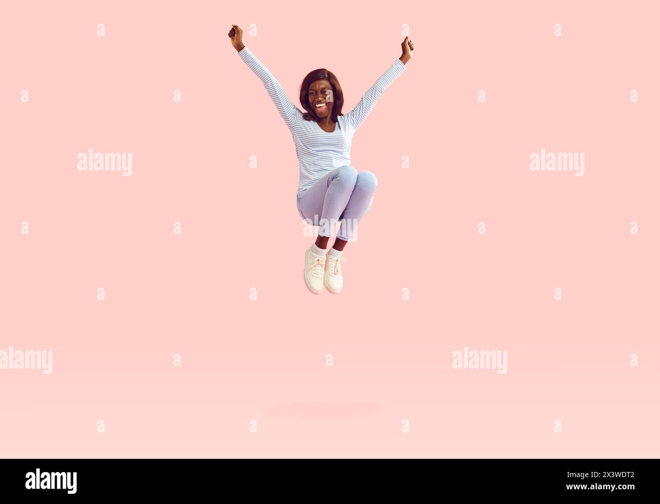 Happy young cheerful African American woman jumping on trampoline and ...