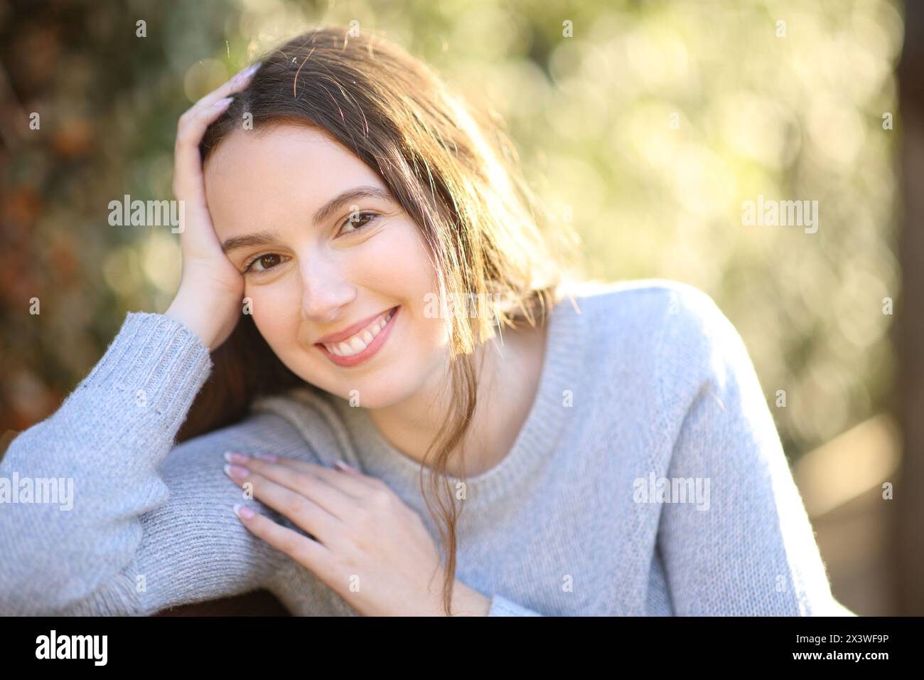 Happy candid woman posing looking at camera smiling in a park Stock Photo