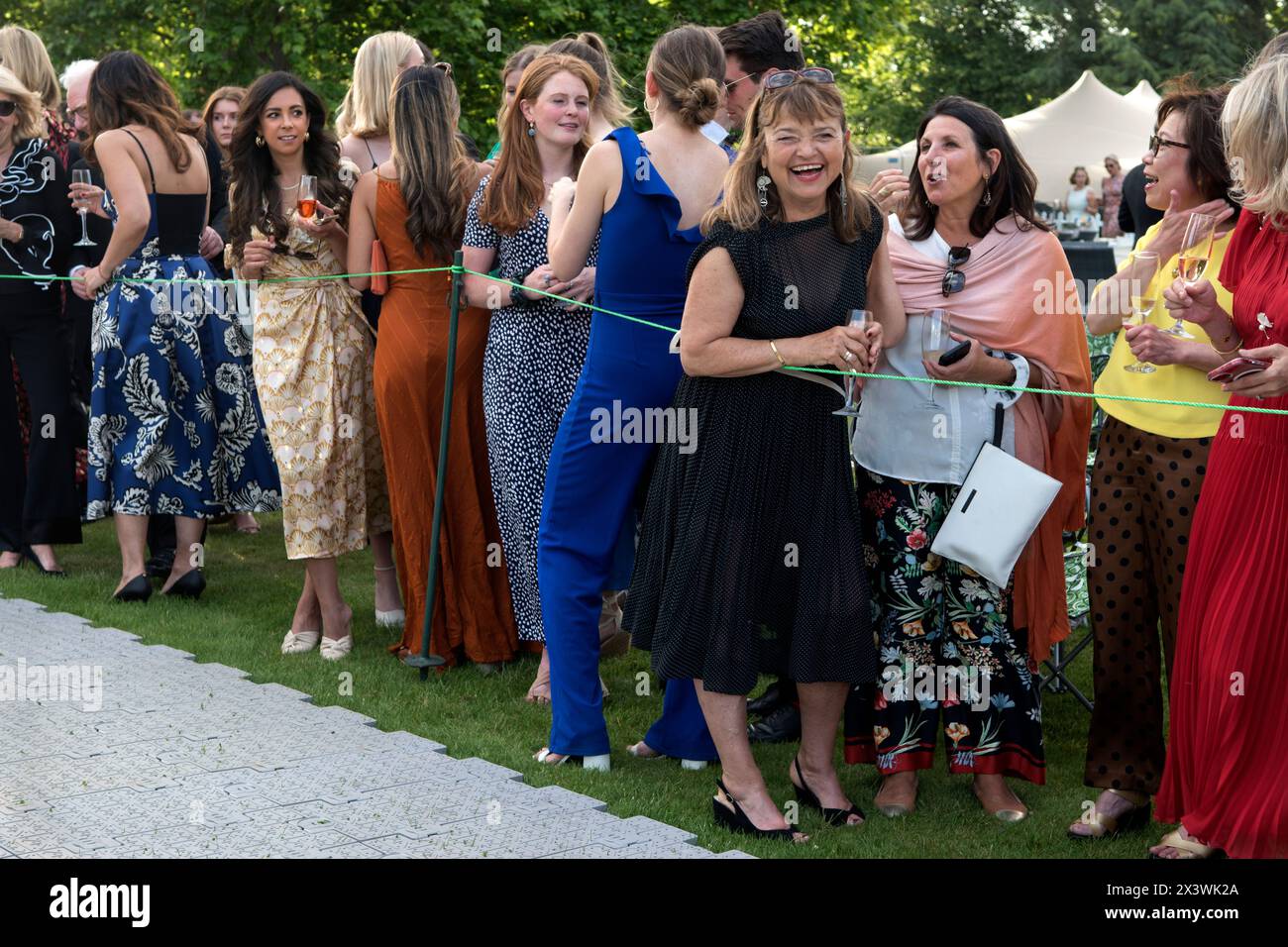 London rich wealthy women at the Hurlingham Club which is an exclusive private social club. The annual summer garden party - Fête Champête, and the showing off, of members classic cars in the Concourse d'Elégance; the cars are driven around the club grounds. ladies waiting for next car to go past. London, England 11th June 2022 UK 2020s HOMER SYKES Stock Photo