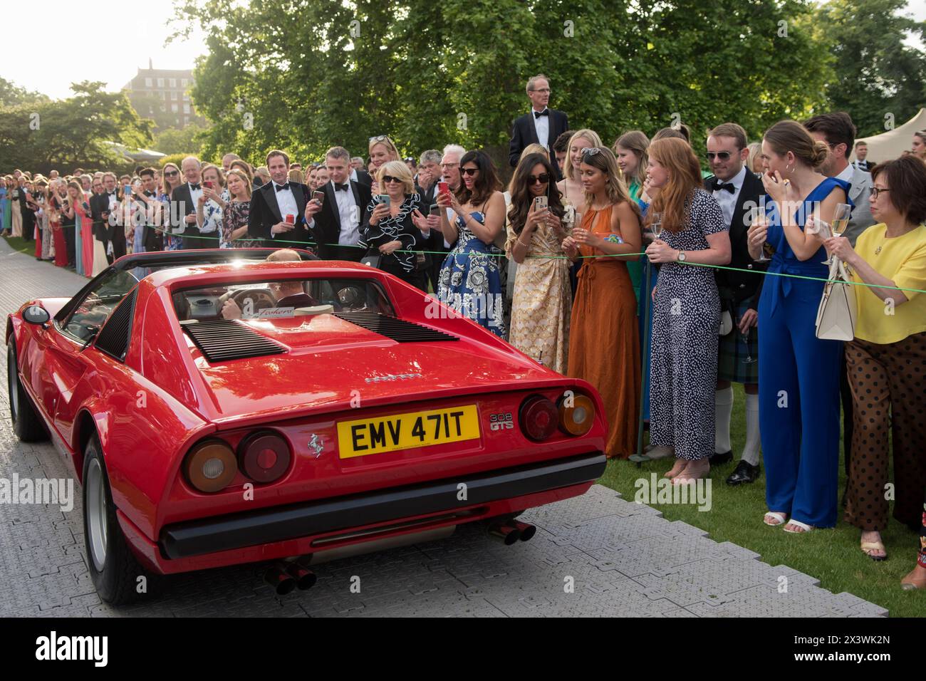 Wealthy London the Hurlingham Club annual summer garden party, members watching a red Ferrari 308 GTS in the Concourse d'Elégance. Members show off their vintage and classic cars in the Concourse d'Elégance, ie owners drive the cars around the grounds of the club. Fulham, London, England 11th June 2022 UK 2020s HOMER SYKES Stock Photo