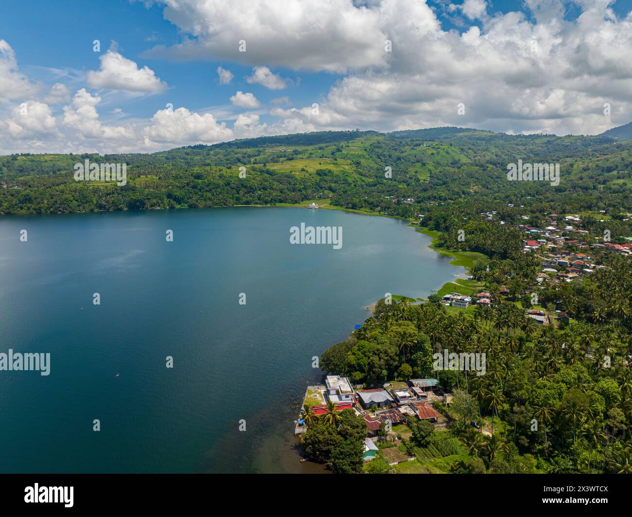 Butig Lake Lanao and small town in lake coast. Mountain green forest. Blue ...