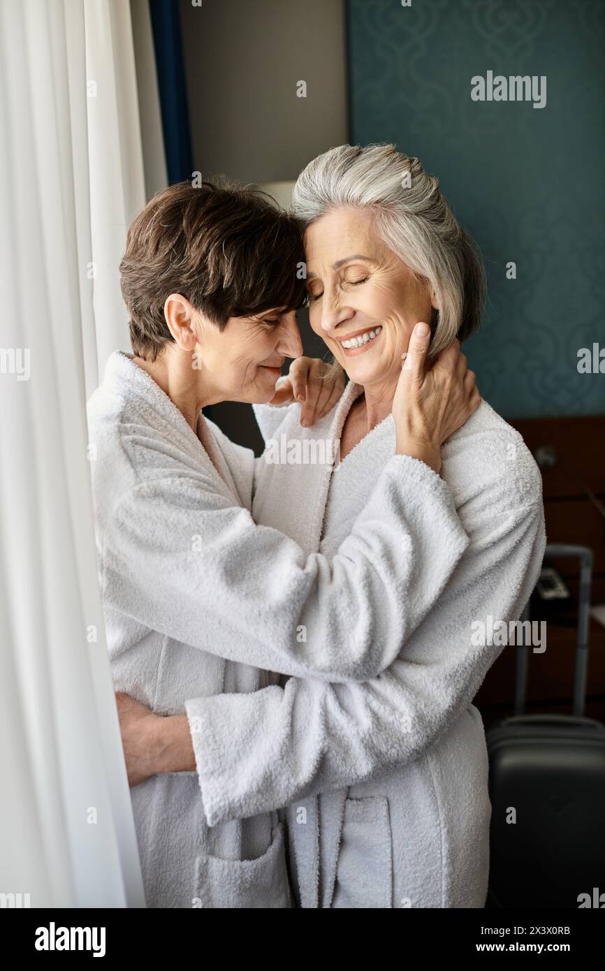 Tender moment as older woman embraces her partner in hotel. Stock Photo