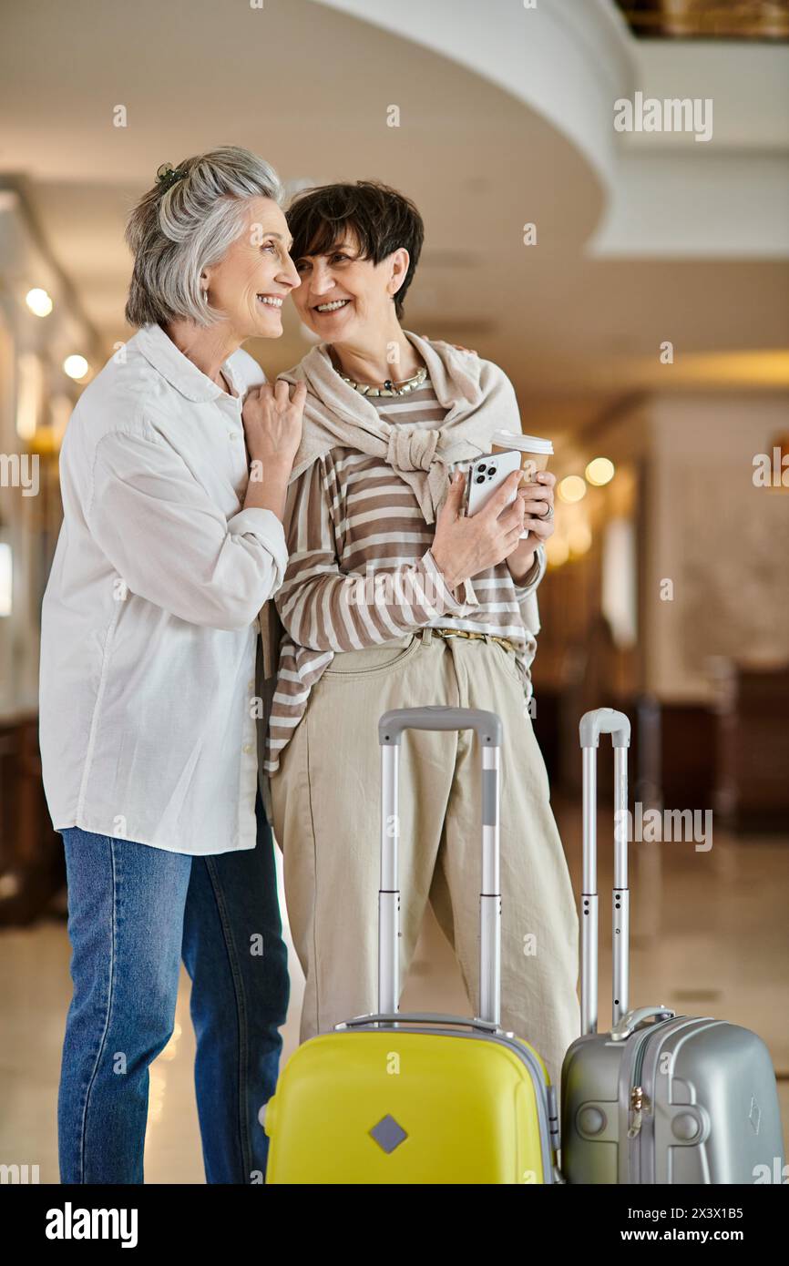 Senior lesbian couple standing together with a tender embrace. Stock Photo
