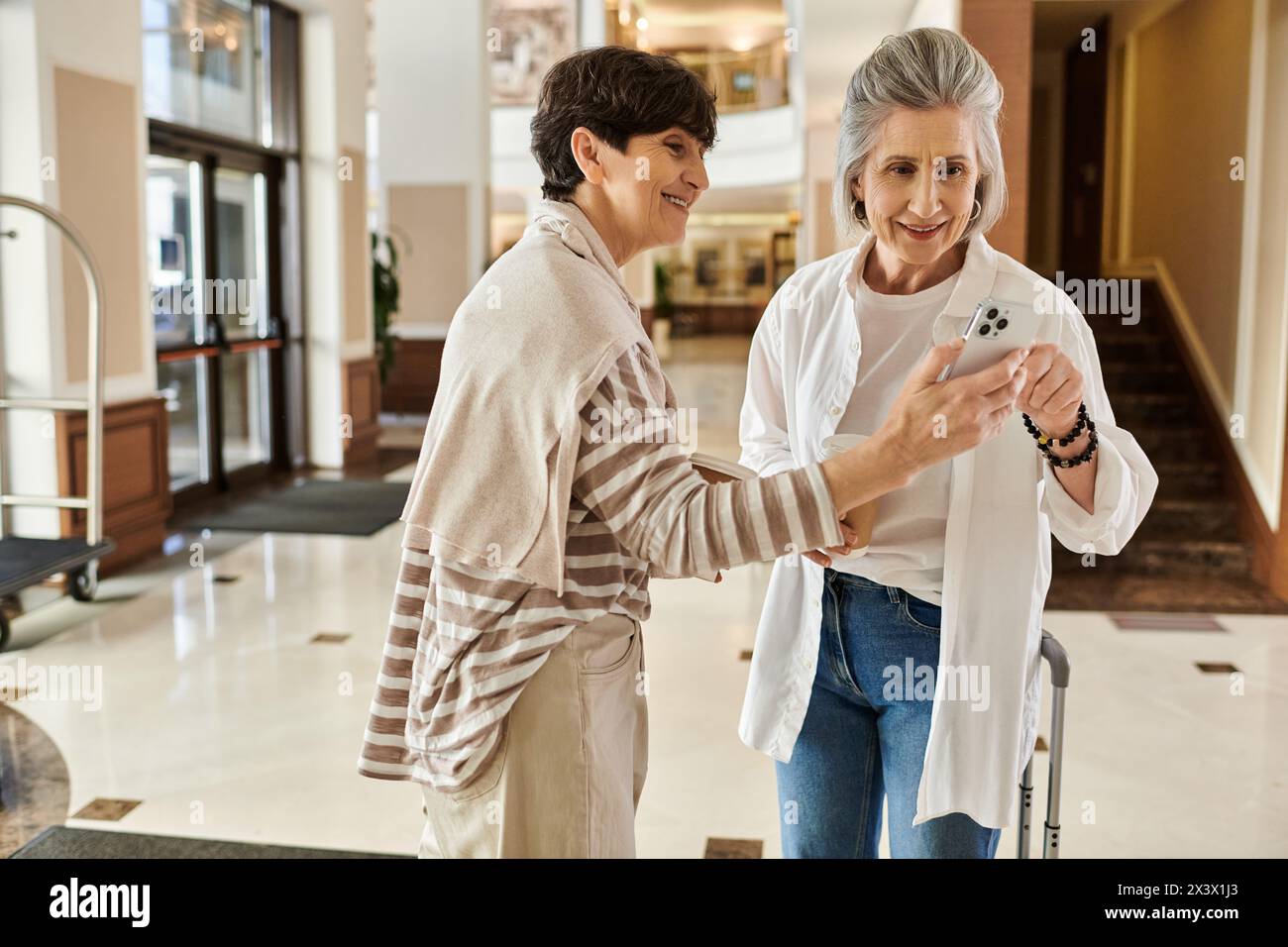 Senior lesbian couple share a moment while looking at a cell phone. Stock Photo