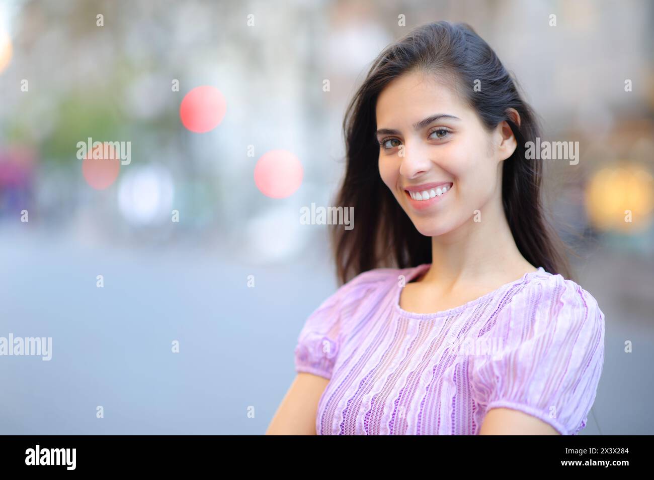 Portrait of a happy woman with perfect smile in the street looking at camera Stock Photo