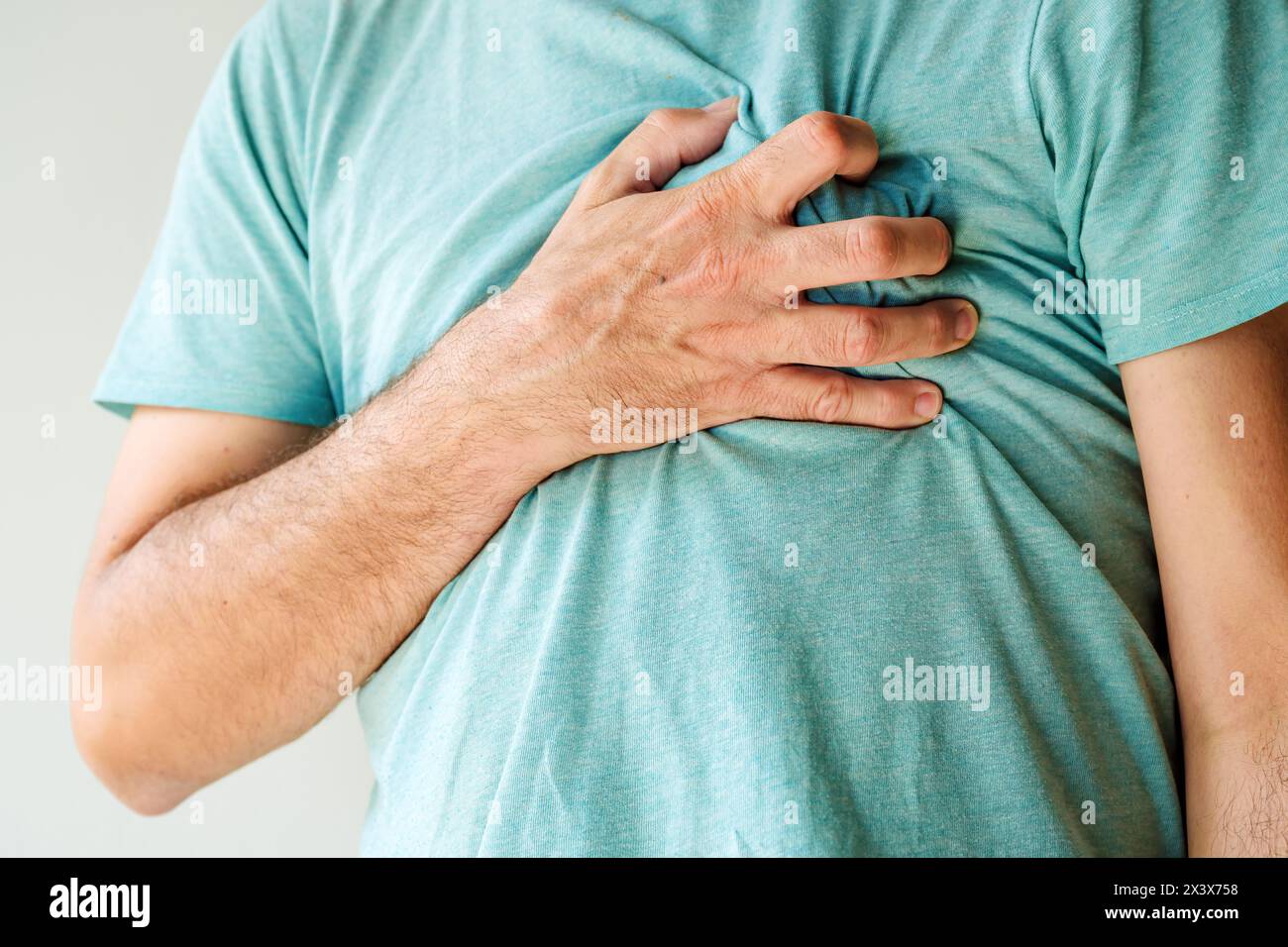 Heartache, chest pain and heart attack concept. Man with painful symptoms of a heart disease. Selective focus. Stock Photo