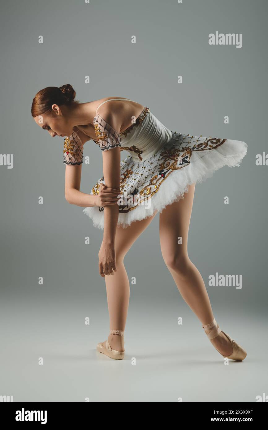 A young, beautiful ballerina dances gracefully in a stunning white and gold  dress Stock Photo - Alamy