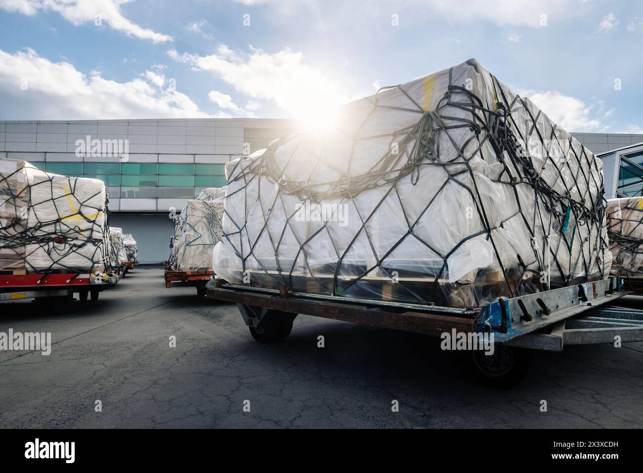 Preparation freight for cargo airplane. Containers at airport during sunny day. Stock Photo