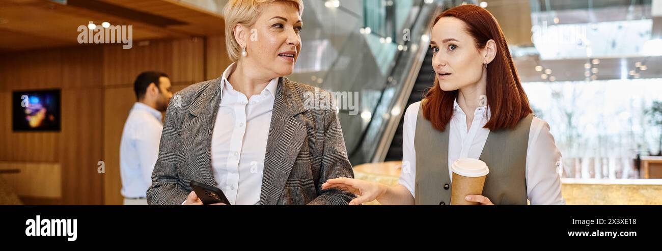 Two women of different races are standing and conversing. Stock Photo