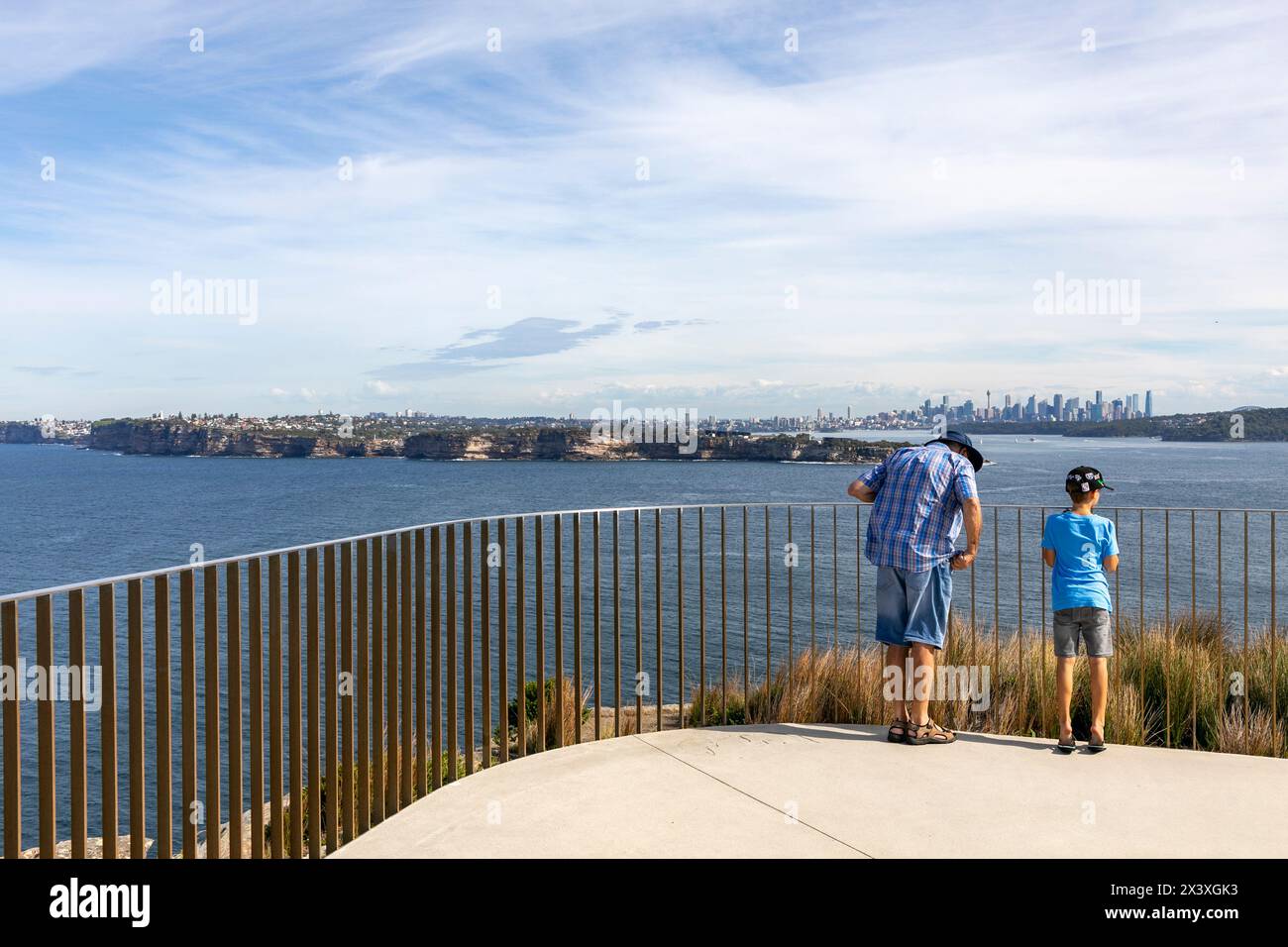 North Head Manly, father and son stand at Burragula lookout view towards South Head and Sydney city centre skyline and cityscape,NSW,Australia Stock Photo