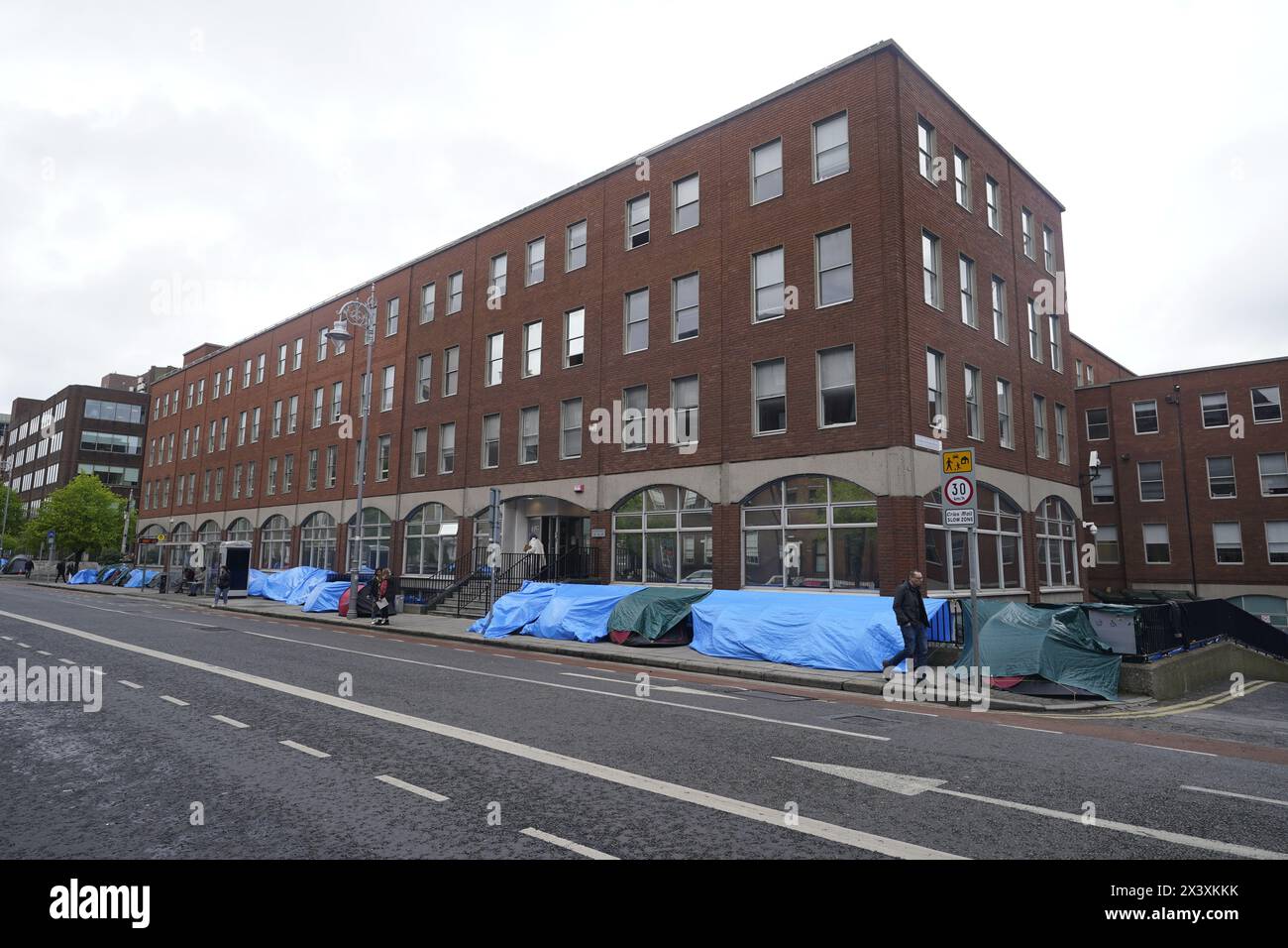 people-walking-past-tents-housing-asylum-seekers-near-to-the