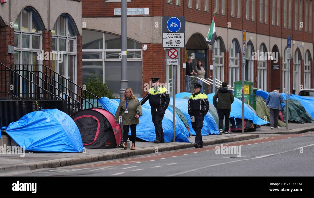 Garda walking past tents housing asylum seekers near to the