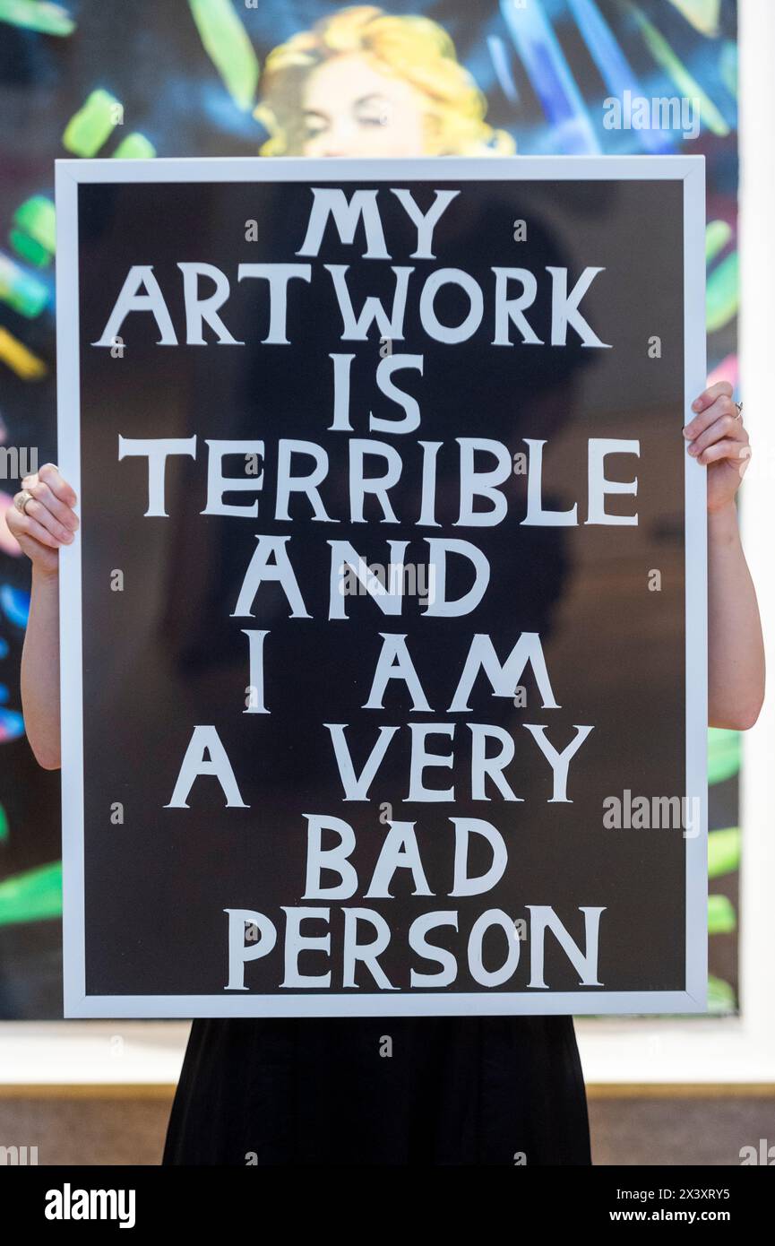 London, UK.  29 April 2024.  A staff member with 'My Artwork is Terrible and I Am a Very Bad Person', 2018, by David Shrigley (Est. £800 - £1,200) at the preview of ‘Hot Off The Press’, a sale of prints and new editions, created and published within the last fifty years, by well-known contemporary artists.  The works will be auctioned at Bonhams New Bond Street on 1 May.  Credit: Stephen Chung / Alamy Live News Stock Photo