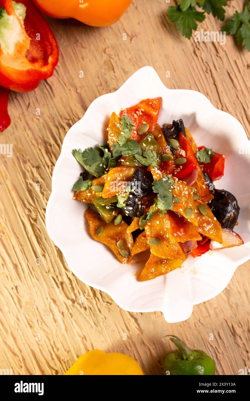 A delicious and nutritious plate of stir-fried pumpkin with black fungus and red peppers, a perfect combination of flavors and textures. Stock Photo