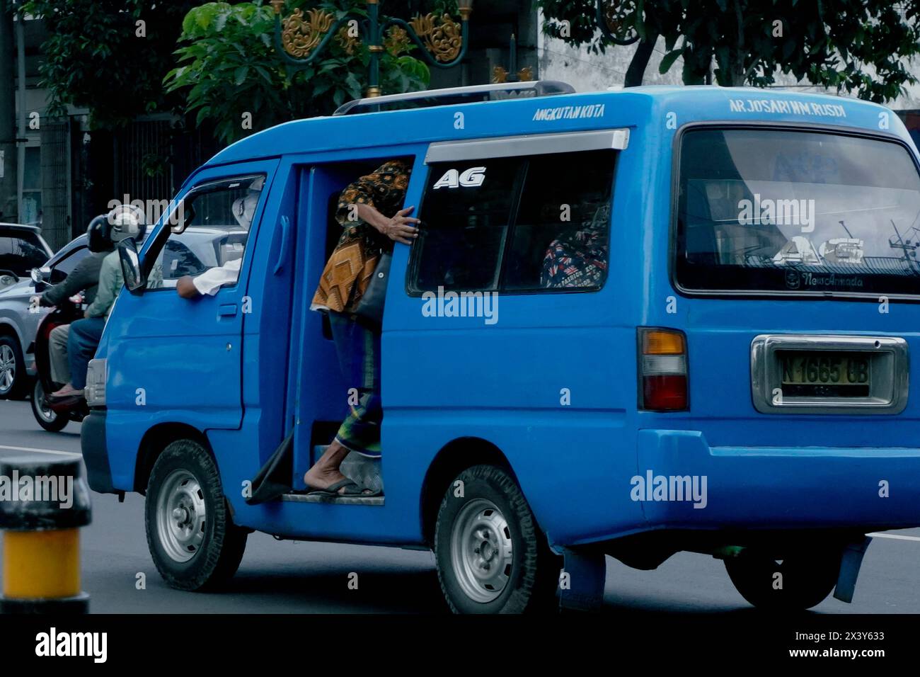 An old man who wants to take public transportation in the city of Malang, Indonesia in the afternoon Stock Photo