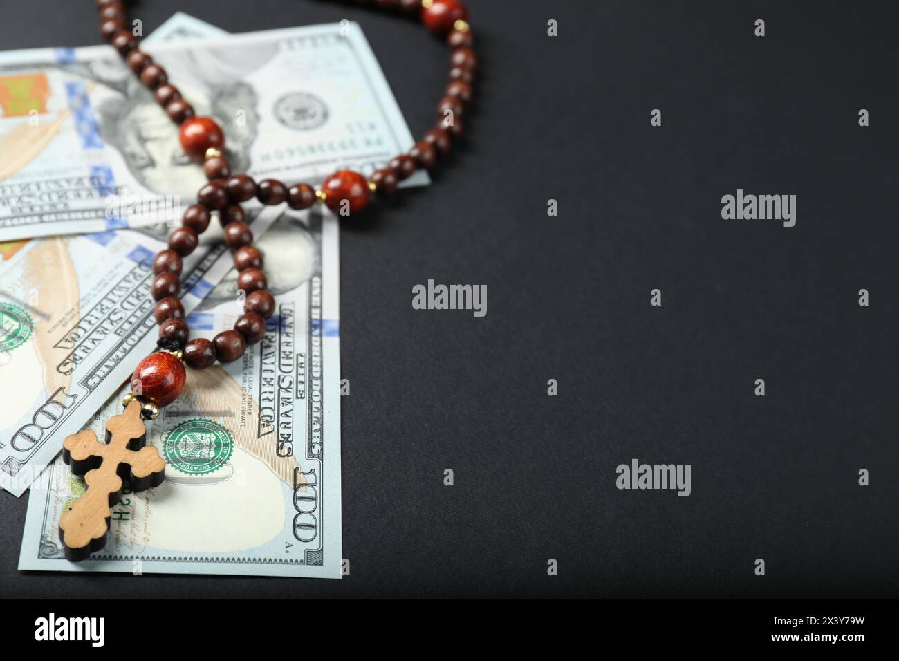 Dollars and prayer beads on grey table, space for text Stock Photo