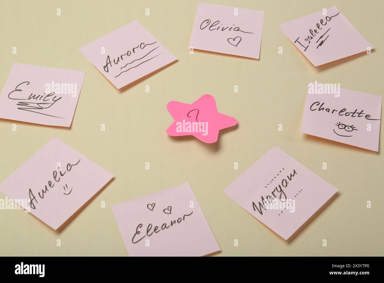 Choosing baby name. Paper stickers with different names and question mark on beige background Stock Photo