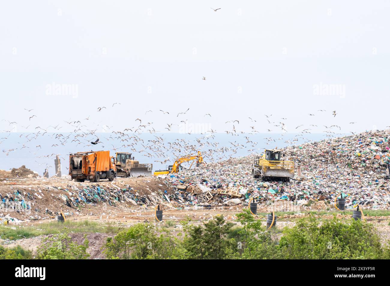 Machines are working on a dumb with sea on a background Stock Photo