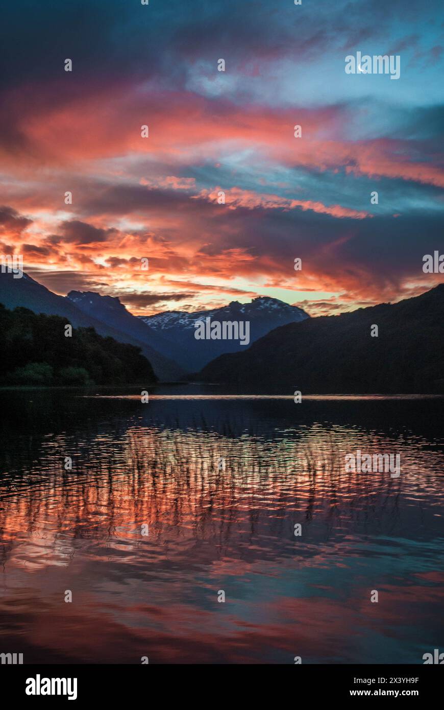 breathtaking sunset over a serene lake with mountains in the background ...