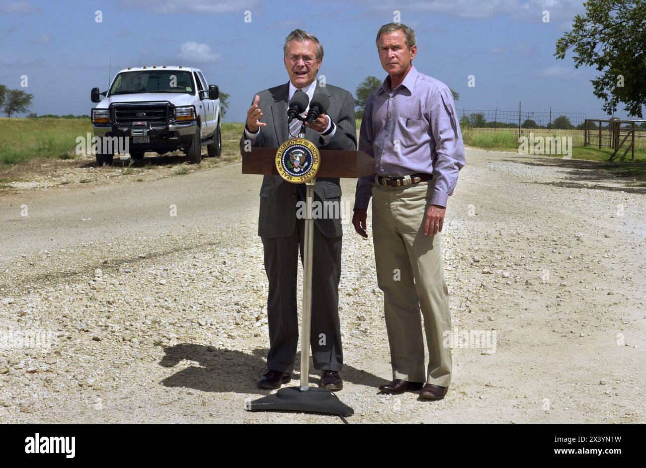 President George W. Bush and Secretary of Defense Donald Rumsfeld during a press conference at the President's ranch in Crawford, Texas, August 21, 2002.  Rumsfeld flew in from Was Stock Photo