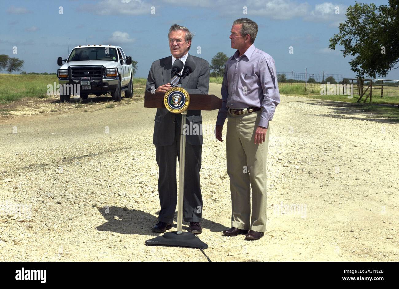 President George W. Bush and Secretary of Defense Donald Rumsfeld during a press conference at the President's ranch in Crawford, Texas, August 21, 2002.  Rumsfeld flew in from Was Stock Photo