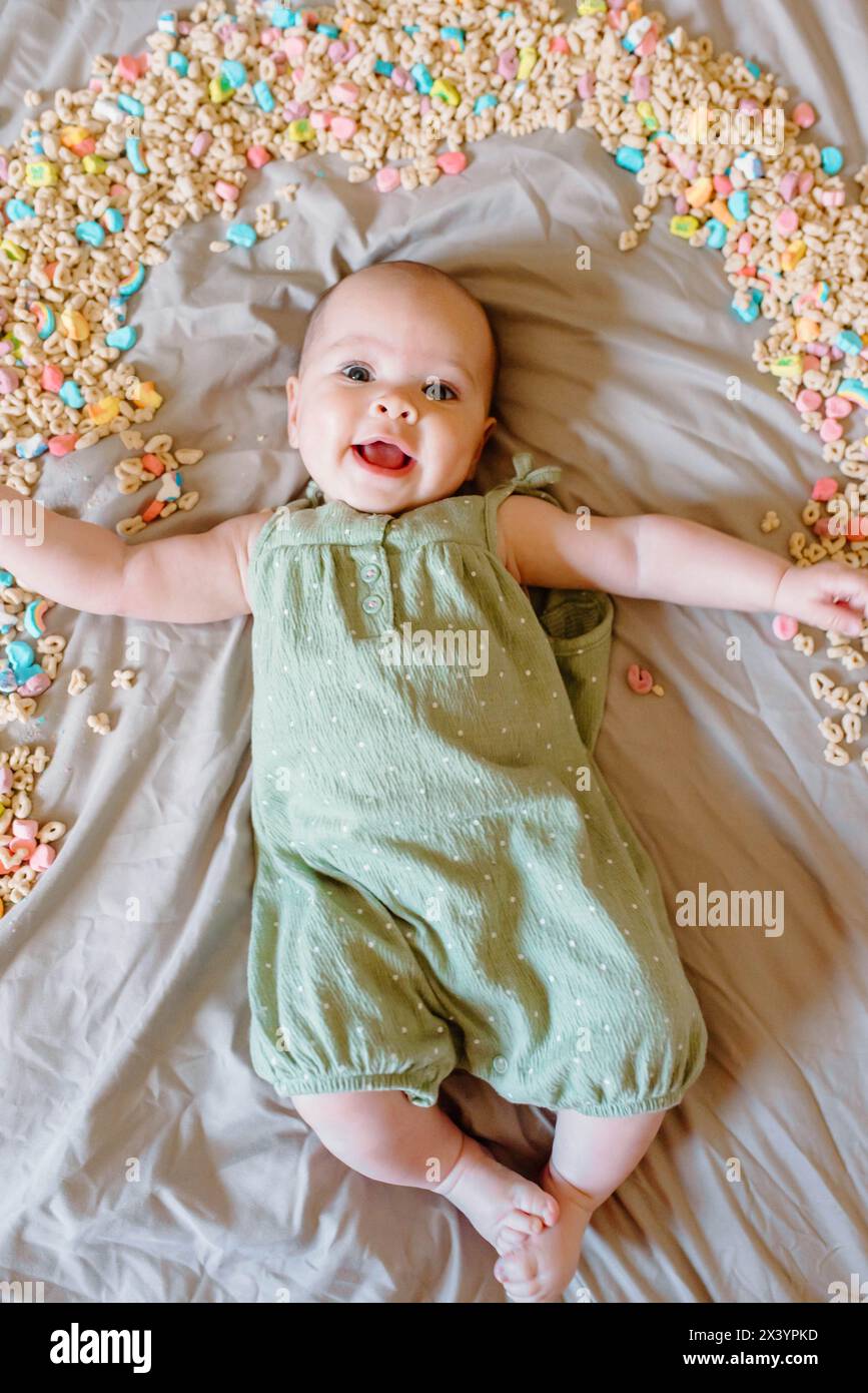 Smiling baby with cereal rainbow, celebrating St. Patrick's Stock Photo