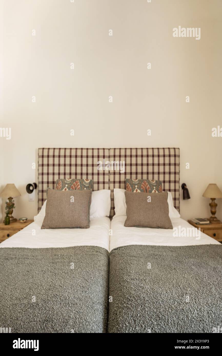 Bedroom with single beds pushed together, wooden bedside tables, fabric