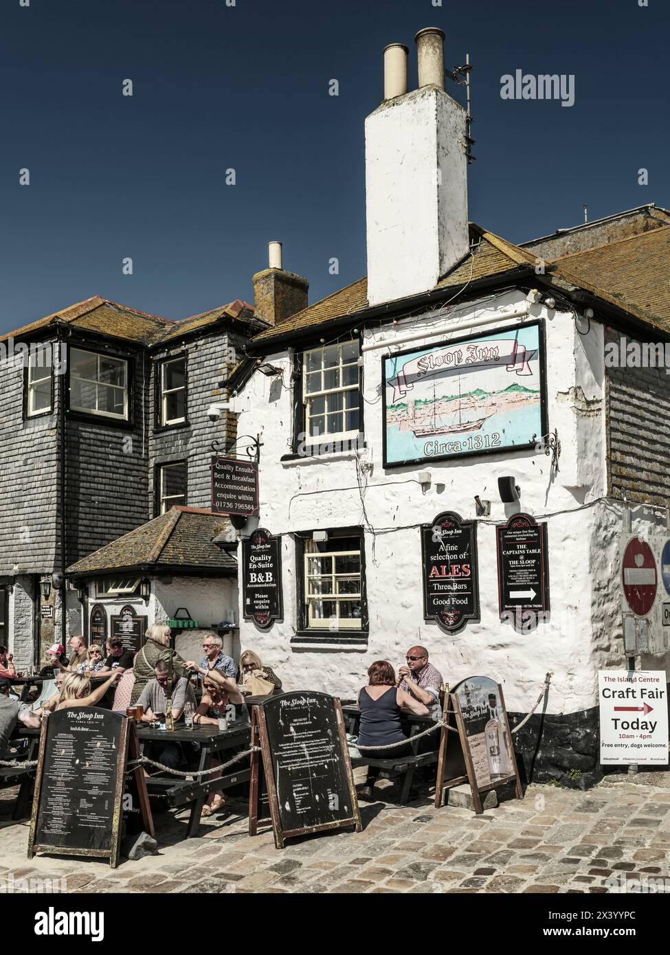 The Sloop Inn is one of the oldest inns in Cornwall, dating back to 1312, with the current 17th century building standing on the quay at St Ives overl Stock Photo