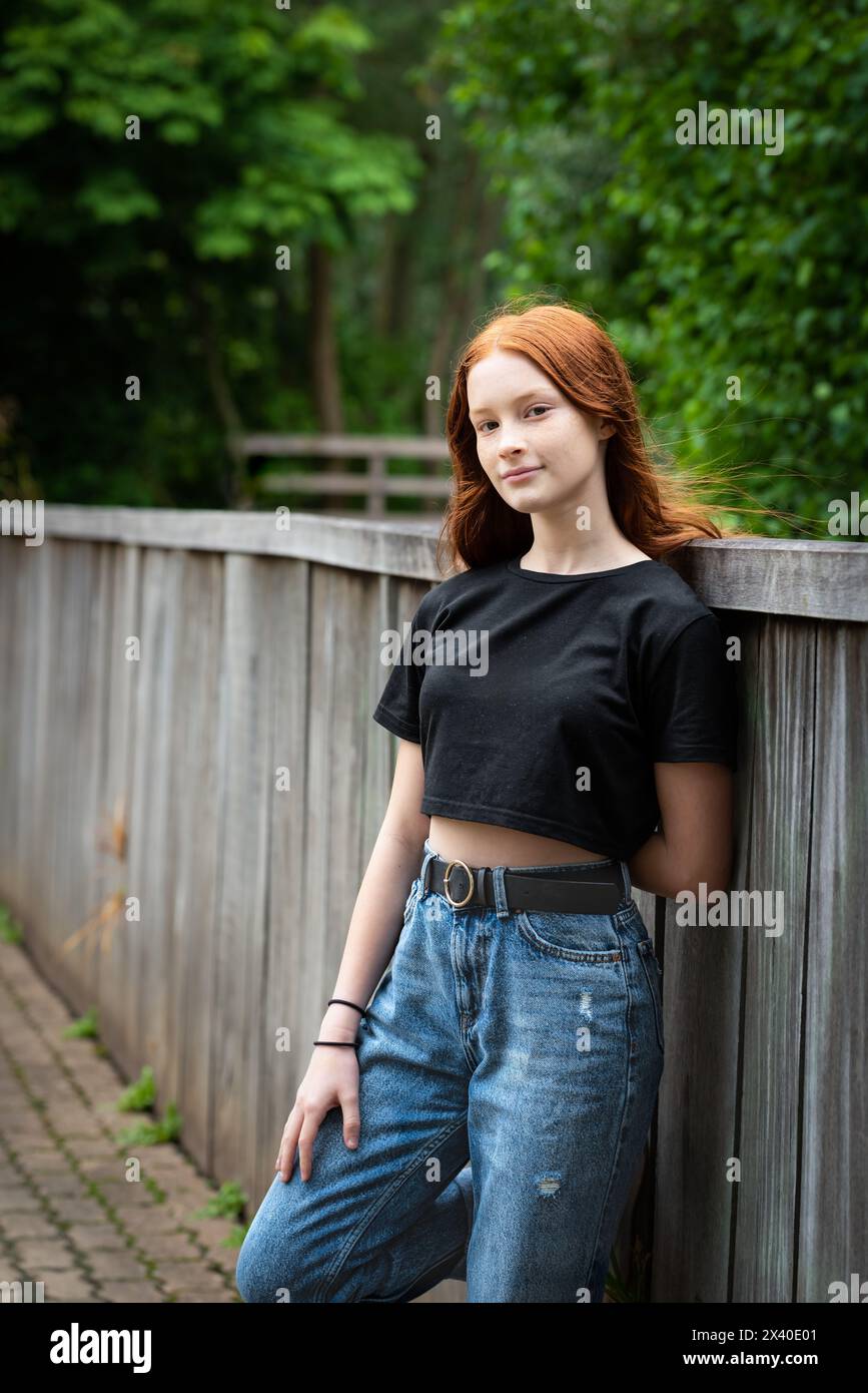 Woman leaning against a fence hi-res stock photography and images - Alamy